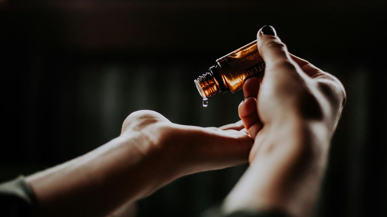 two hands holding a bottle of serum
